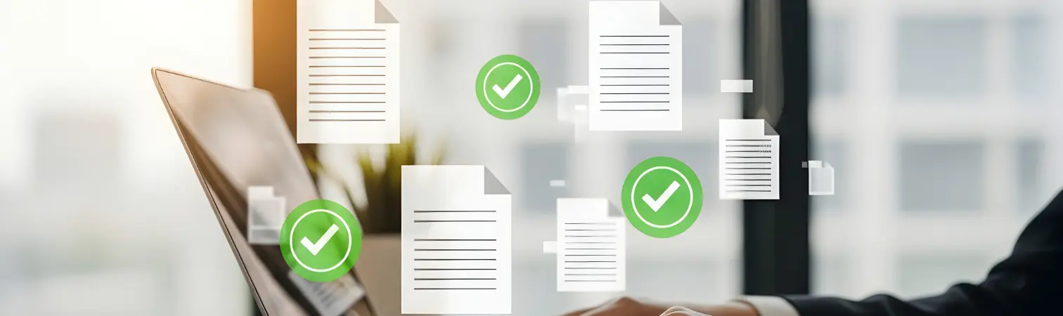 Photo of a laptop with illustrated documents and green check marks floating above it.