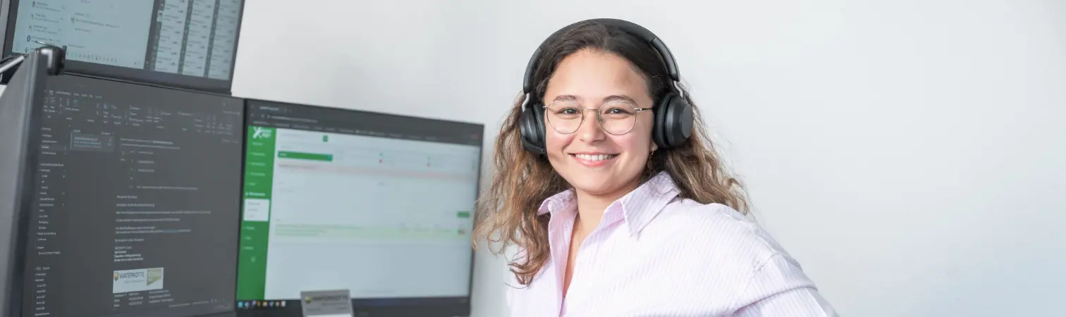 WATERKOTTE employee wearing a headset in front of a screen with a service programme.