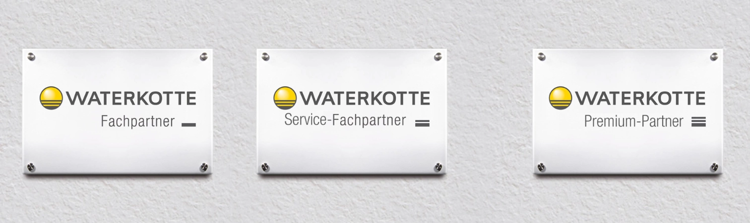 Signs mounted side by side on the wall with the inscriptions “Fachpartner” “Service-Fachpartner” and “Premium Partner.”