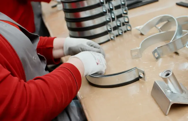 Close-up of an employee’s gloved hands assembling a hose clamp.