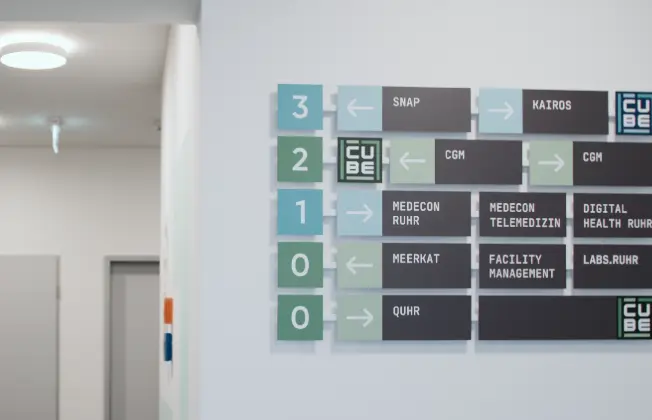 Signage with various company names on an interior wall.