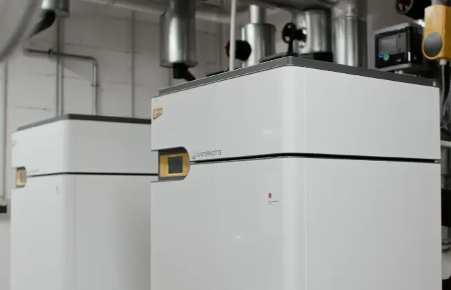 Side view of a WATERKOTTE heat pump in the plant room of the CUBE17 administrative building.