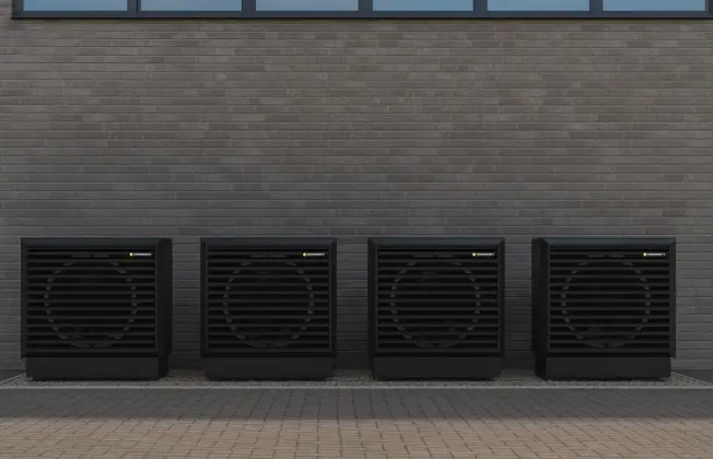 Air source heat pump outdoor units in cascade in front of a modern building.